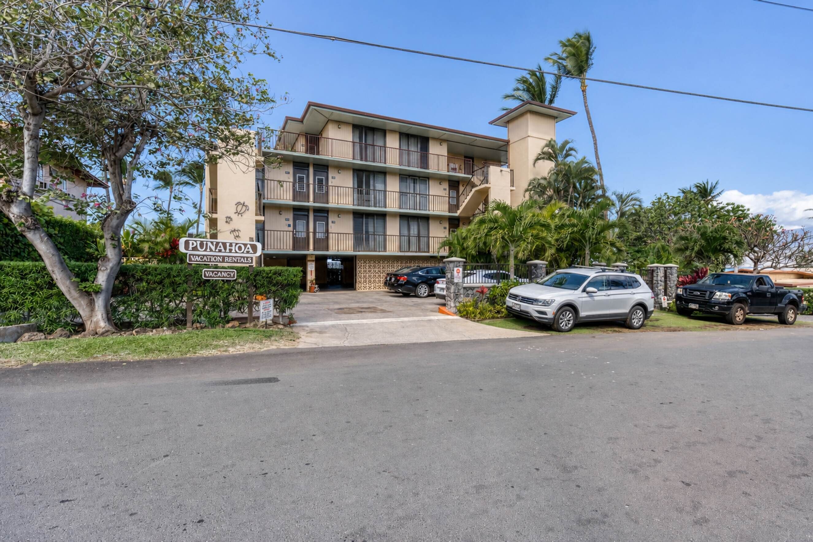 A multi-story building with a sign indicating 'PUNAHOA VACATION RENTALS.'