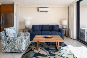 A living room with a sofa, a chair, a coffee table, and two lamps.