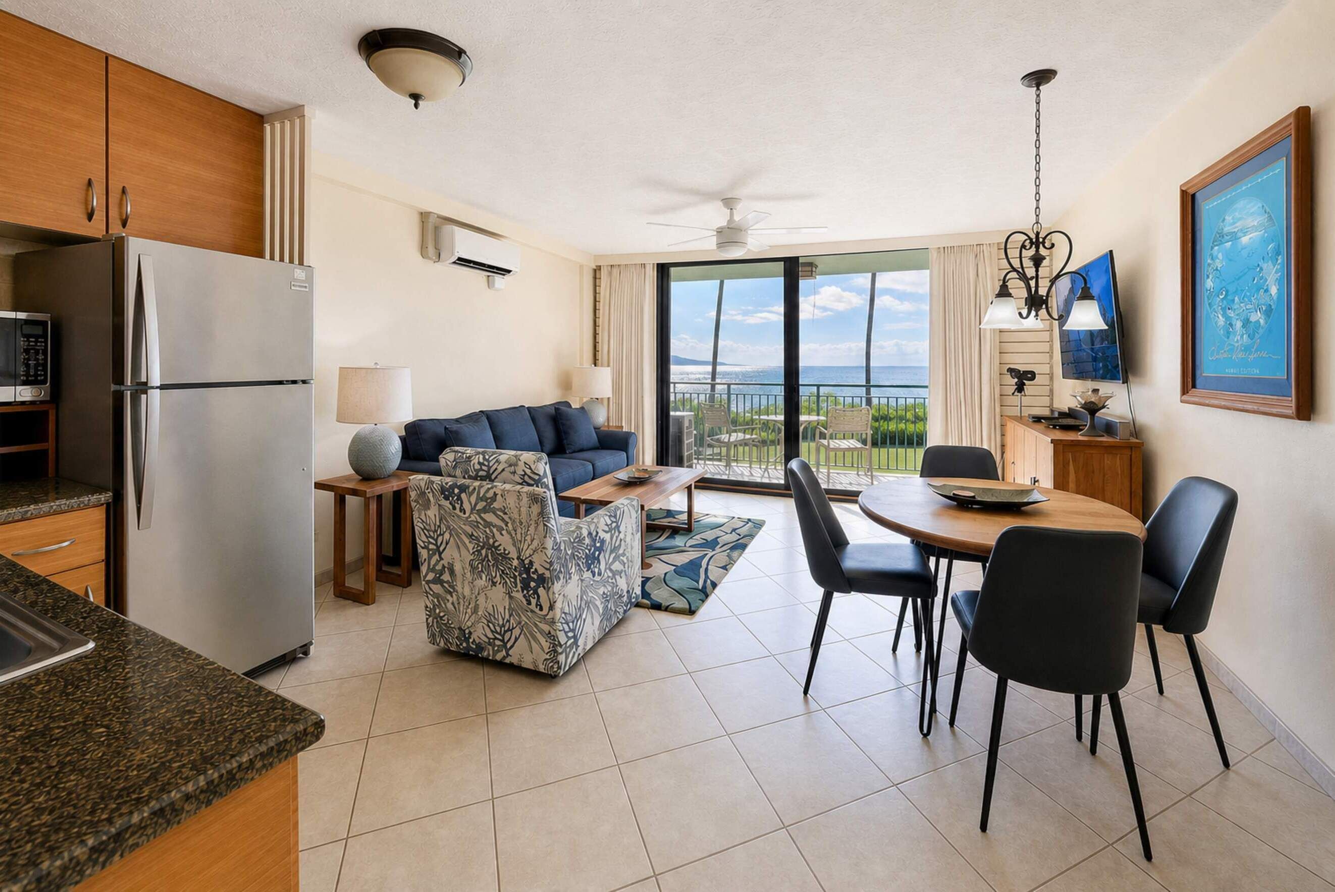 Una cocina moderna con refrigerador, microondas y un comedor con mesa y sillas.