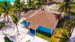 A beachfront property with a tiled roof, a swimming pool, and palm trees. - 2 bedroom 2 bathroom beach house, beach right at your door steps, (Steventon)