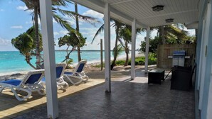A covered outdoor area with lounge chairs facing a beach. - 2 bedroom 2 bathroom beach house, beach right at your door steps, (Steventon)