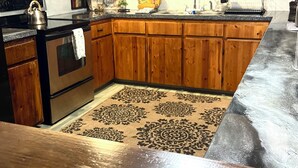 A kitchen with dark grey cabinets, stainless steel appliances, and a patterned rug. - Enjoy a cozy holiday getaway in our peaceful rural home.
WIFI NOT AVAILABLE (Mead)