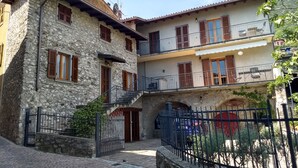 A stone building with a balcony and a gated entrance. - Holidayapartments in beautiful house, private garden, free Wi-Fi (Tignale)