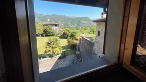 A view through a window of a stone building with a stone wall and a wooden ceiling. - Holidayapartments in beautiful house, private garden, free Wi-Fi (Tignale)
