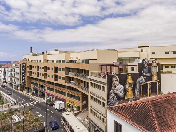 A multi-story building with a modern architectural style, featuring balconies and large windows. - Building in the Funchal centre, Drapes Design (Funchal)
