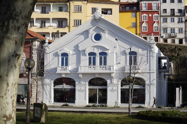 A white building with arched windows and a balcony, featuring signage for 'bixos' and 'zero'.