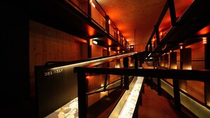 A corridor with bunk beds, wooden walls, and numbered doors. - Zero Box Lodge Coimbra (Coimbra)
