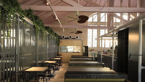 A restaurant with high ceilings, exposed beams, and a central bar area. - Zero Box Lodge Coimbra (Coimbra)
