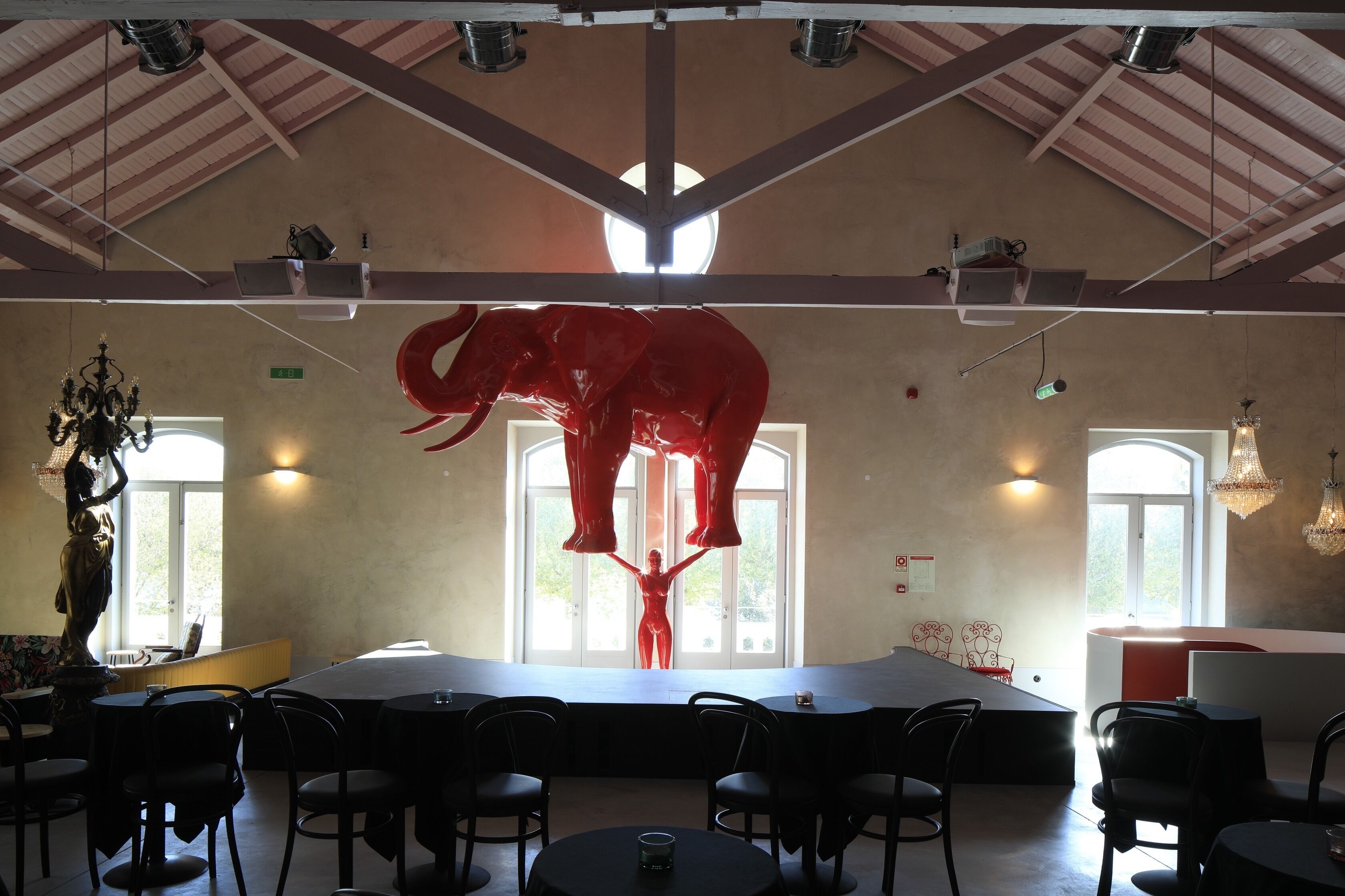Un restaurante con techo alto, vigas a la vista y amplias ventanas.