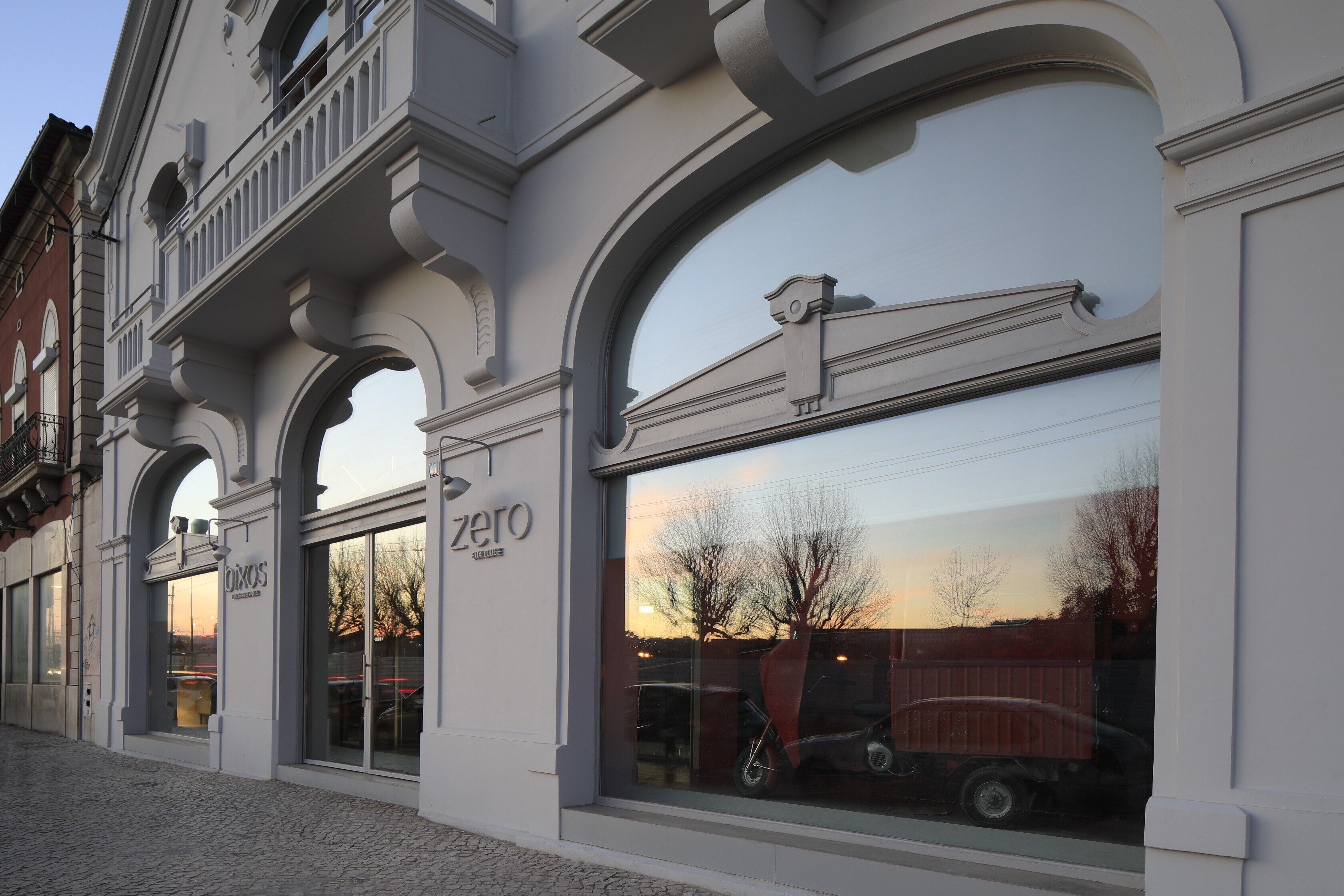 Un edificio con amplios ventanales de arco y un letrero que dice "zero".