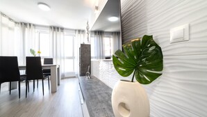 Een moderne hotellobby met een eetgedeelte, een grote potplant en een structuurwand.