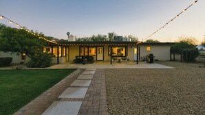 A house with a patio, outdoor seating, and string lights.