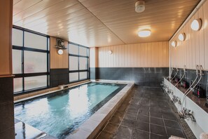 A swimming pool with a tiled floor and a wooden ceiling. There are multiple faucets and bottles on the right side. - Tabist Daibo Ichihara Men Only (Ichihara)
