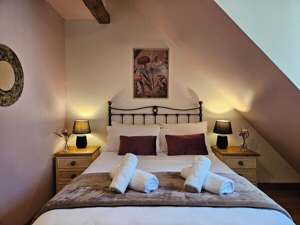 A neatly made bed with white and brown linens, two bedside lamps, a framed floral painting above the bed, and a wooden headboard. - 5-person vacation rental near BEAUVAL and CHENONCEAUX (Bourré)