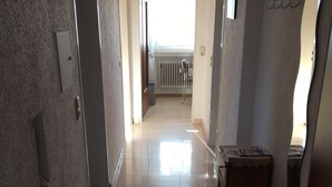A hallway with a radiator, a door, and a small table with magazines. - Vacation apartments Hehner attic (Patersberg)