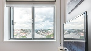 Una stanza con un'ampia finestra che si affaccia su una vista urbana e un ponte.