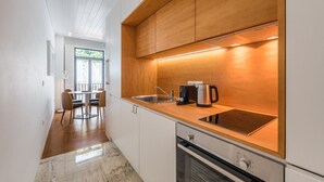 Una cucina moderna con piano cottura integrato, macchina del caffè e lavello.