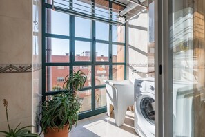 Convenient laundry facilities with a washing machine and drying rack.