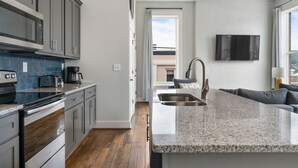 Una cocina moderna con encimeras de granito, electrodomésticos de acero inoxidable y una isla integrada con pileta.