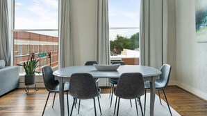 Un comedor moderno con una mesa redonda, seis sillas y una planta en maceta.