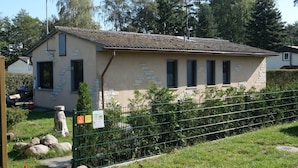A two-story building with a tiled roof, a stone facade, and multiple windows.