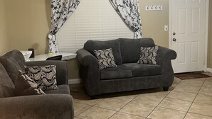 A living room with two sofas, a ceiling fan, and a window with curtains. - Nice 3 bedroom's house owner occ and 2 bathroom with fast WI-Fi,  Full Kitchen (Las Vegas)
