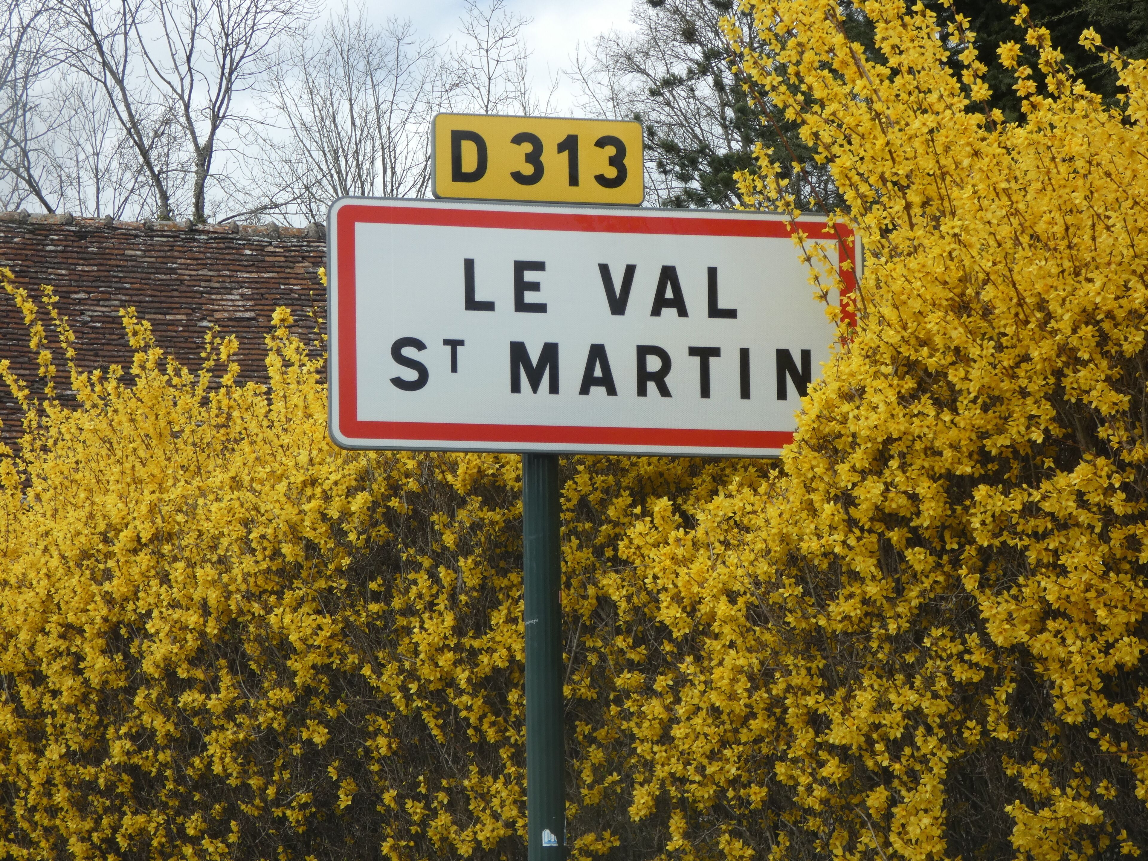 Un panneau de signalisation indiquant « LE VAL ST MARTIN » et « D313 ».