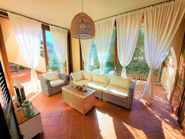 A sunlit living room with a sofa, chairs, and a coffee table.