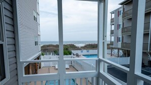 A view from a balcony overlooking a swimming pool and beach. - Updated Oceanview Modern Decor, Private Balcony! (North Myrtle Beach)