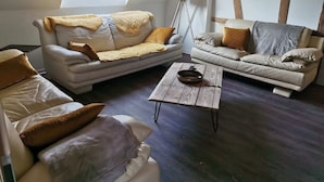 A cozy living room with two sofas, a coffee table, and a floor lamp.