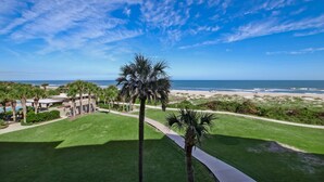A resort with a view of the ocean, palm trees, and a pathway leading to the beach. - AMELIA ISLAND RESORT - TURTLE DUNES OCEANFRONT CONDO WITH POOL/TENNIS (Fernandina Beach)