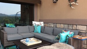 A cozy outdoor seating area with a gray sectional sofa, a wooden coffee table, and a wicker side table. - Forest Estate Guest Quarters-Seclusion- Just Minutes from Town (Woodland Park)