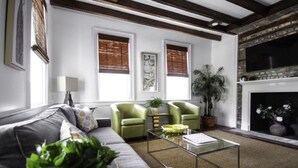 A modern living room with a sofa, two armchairs, a coffee table, and a fireplace. - M1 at Saint Philip Square, One Block to King, Cozy Bright Stay (Charleston)