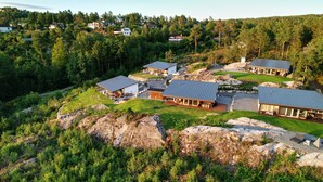 A cluster of modern cabins with metal roofs, surrounded by lush greenery and rocky terrain. - Cottage - Sleeps 14 With Fjord Views (Frogn)