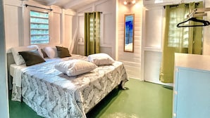 A room with a bed, a dresser, and a window with curtains. - Jungle Cottage Orient Bay: Charming and authentic (Saint Martin)
