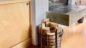 Un salon moderne avec une cheminée, un meuble en bois et une lampe.
