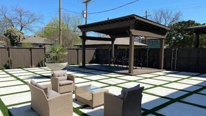 Une terrasse avec des meubles d’extérieur et une pergola.