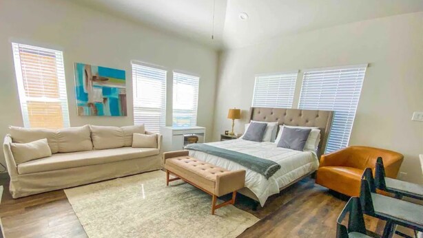 A bedroom with a bed, a sofa, a bench, and a chair. - Cozy Studio Walk to Lower Greenville Dallas - Pet-Friendly, W/D, BBQ, Parking (Dallas)