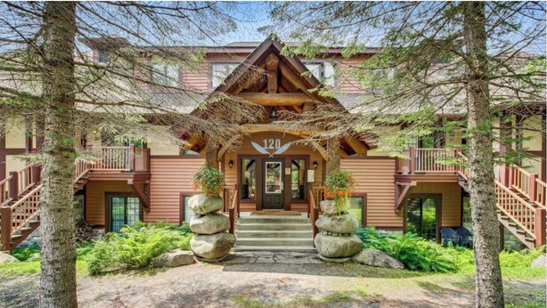 A lodge with a wooden exterior, a central entrance, and a number '120' above the door. - Superb ski in/out - Ask about summer pool access! (Mont-Tremblant)