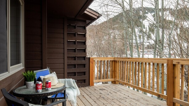 A wooden deck with a table and chairs, a potted plant, and a blanket. - Outpost: Pitchfork 432 - Close to Snow King Mtn! (Jackson)