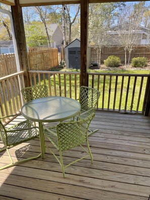 Relax on the covered deck with a round table and two chairs.