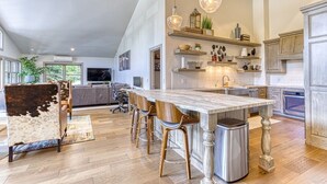 A spacious kitchen with a large island, wooden chairs, and pendant lighting. - Beautiful Townhouse near ski slopes, biking trail, & 1 mile from the main street (Park City)