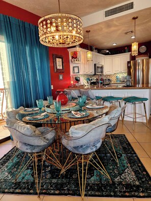 A dining area with a round table, chairs, and a chandelier.