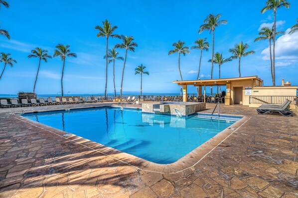 Relax by the ocean-view pool surrounded by lounge chairs and umbrellas.