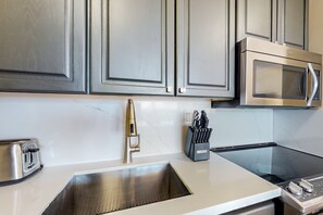 Enjoy cooking in this well-equipped kitchen with a stainless steel sink, microwave, and toaster.