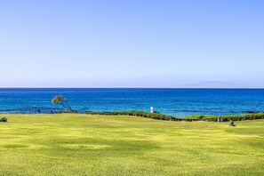 Stroll along the grassy path to the clear blue sea, where a historic lighthouse stands sentinel.