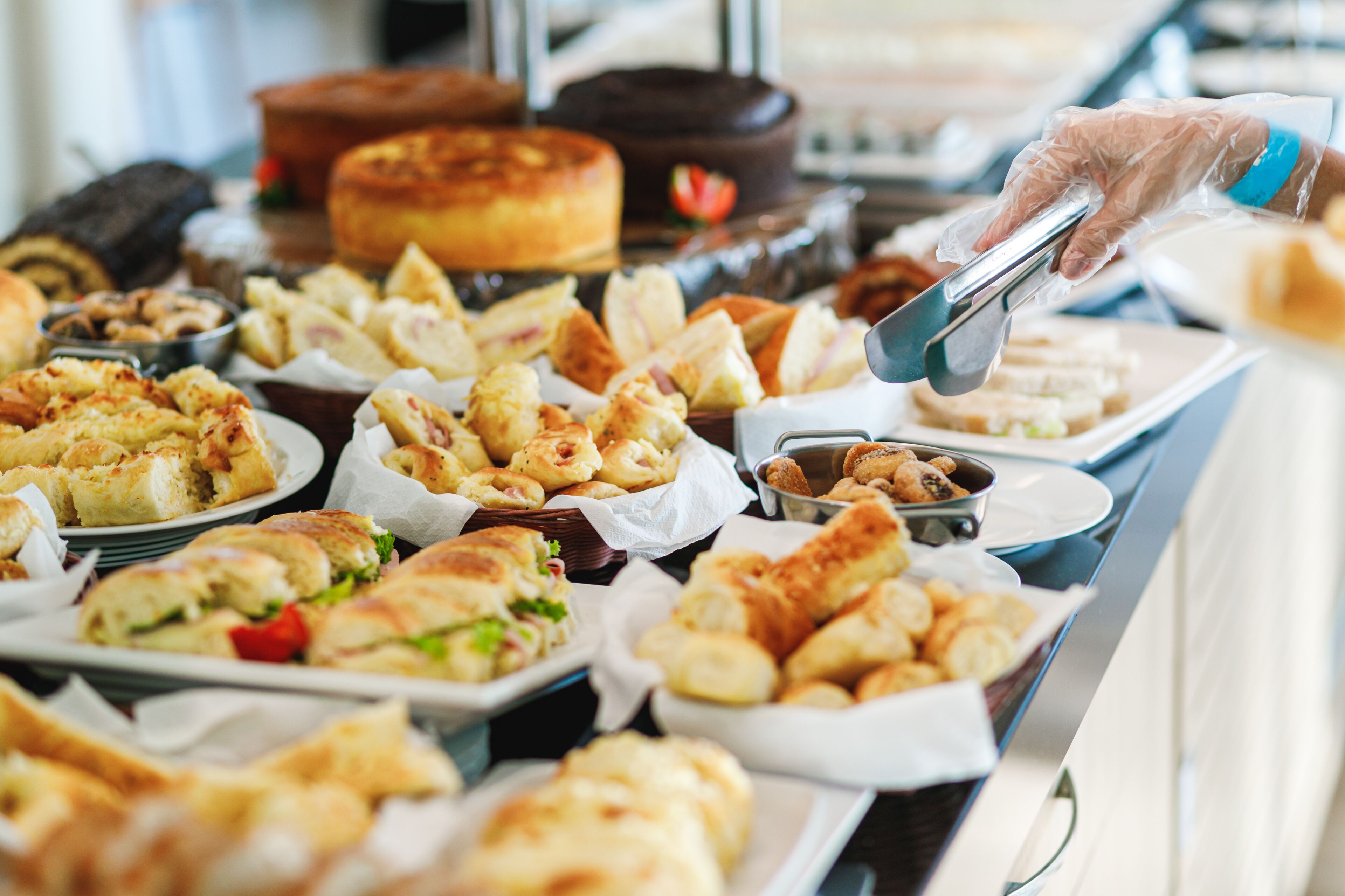 A buffet with various food items including sandwiches, pastries, and desserts.