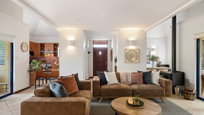 Een moderne woonkamer met een zithoek, een salontafel en een open haard.