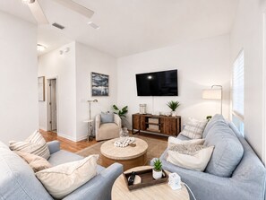A modern living room with a sofa set, a coffee table, a TV, and a wooden cabinet.