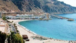 A coastal resort with a beach, a pier, and a mountain backdrop. - Sunny Seaside Apartment in Aguadulce (AGUADULCE)